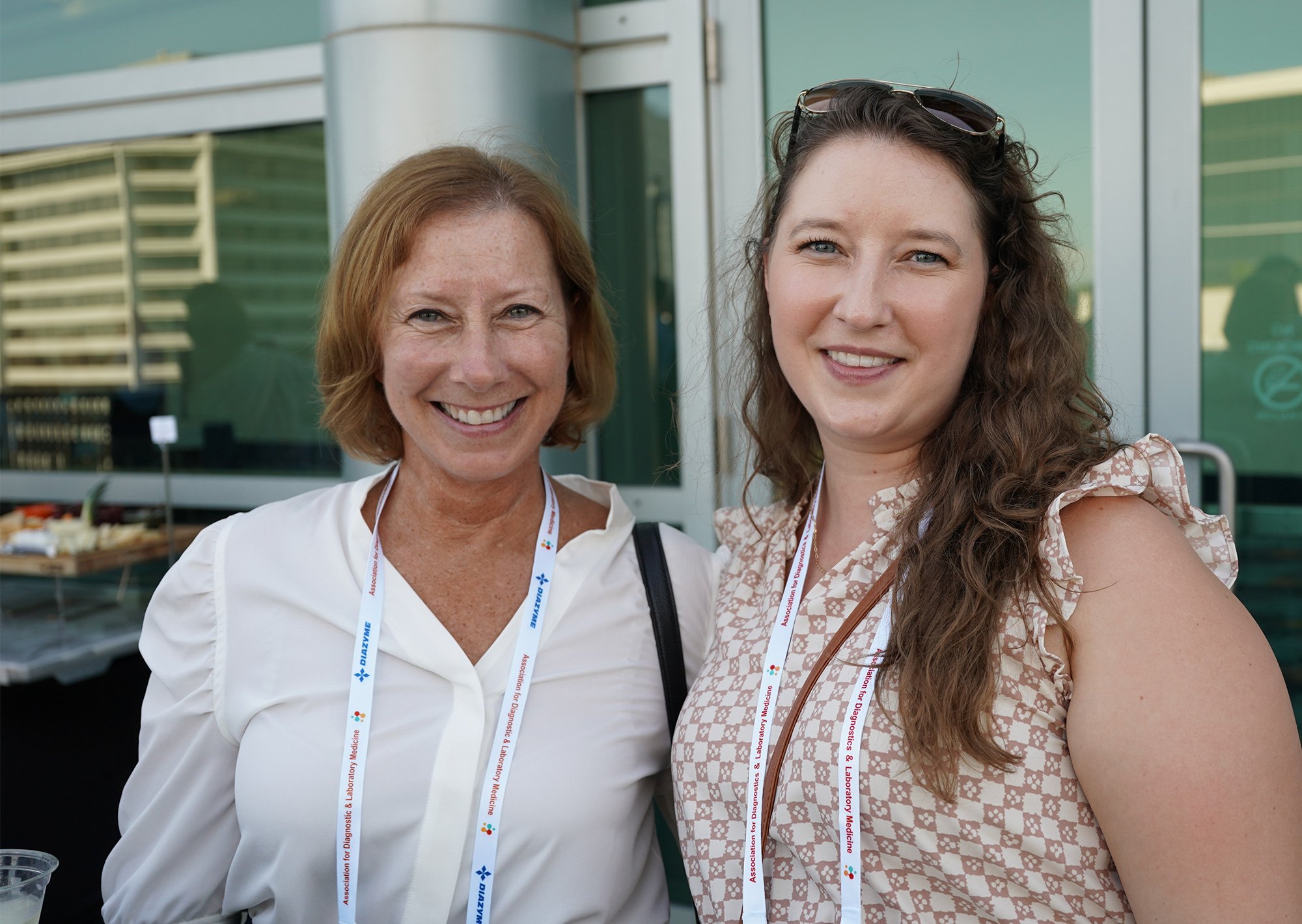 Two women posing and smiling for a picture.