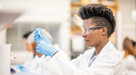 Lab worker looks at test tube
