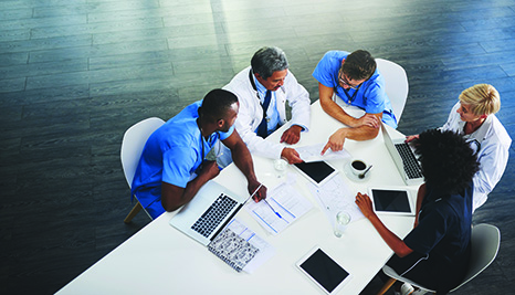 Birds eye view of doctors at a table looking over papers