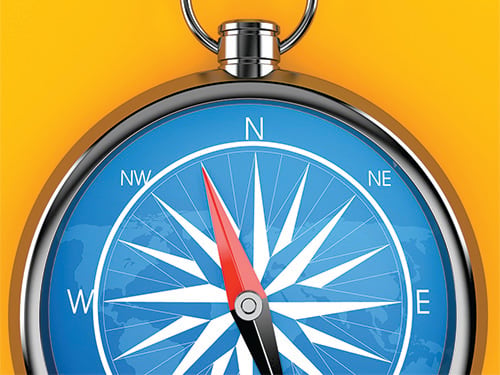 A blue compass in front of a yellow background