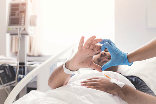 Patient and laboratorian make heart with their hands