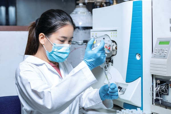 A laboratorian pipettes in the lab.