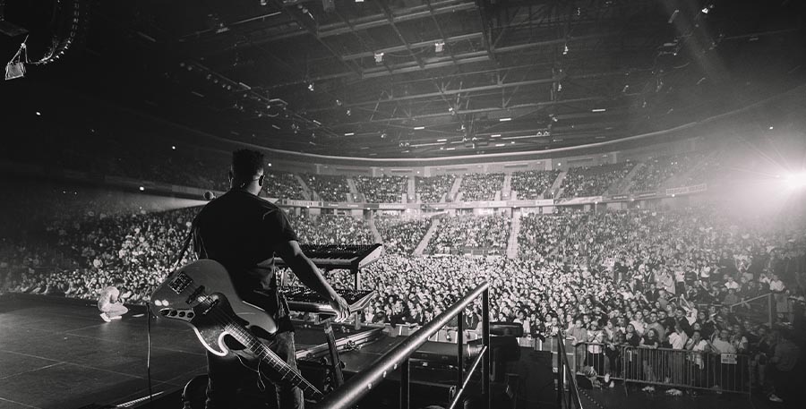 Black and white photo of Khalid on stage looking out into the audience