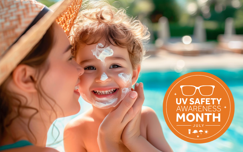 A person applies sunscreen to a child's face by a swimming pool.
