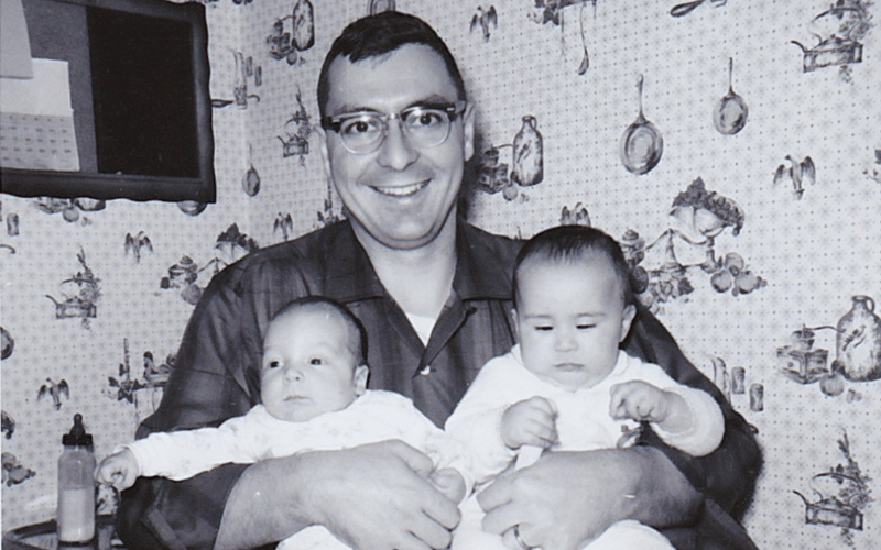 John E. Riedel with two babies in black and white photo. 