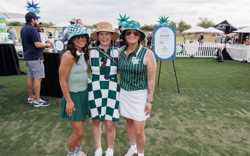 Three female host committee members for golf tournament.