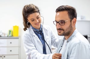 Female physician checking patient's heart. 