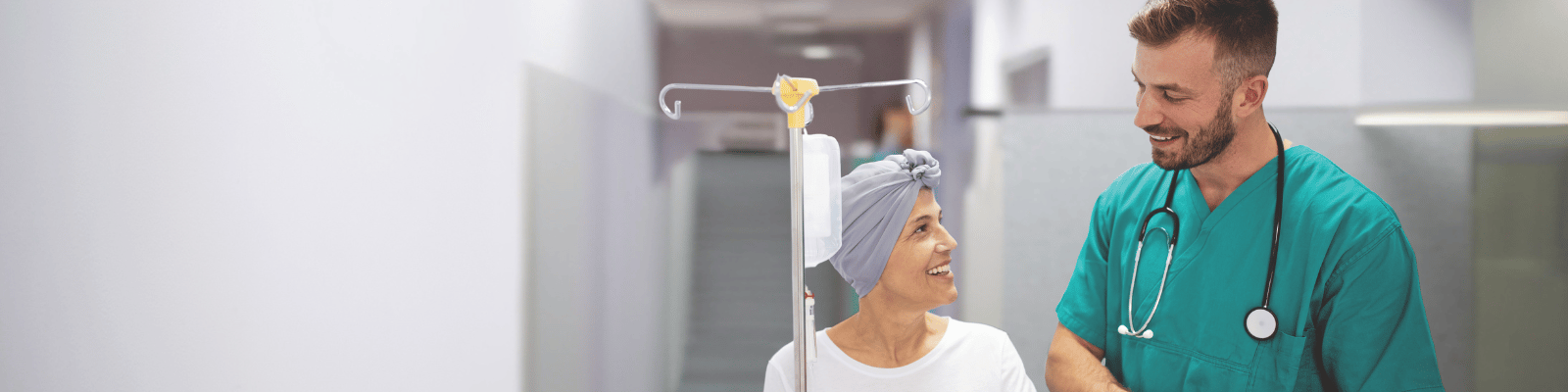Male healthcare worker assisting female cancer patient. 