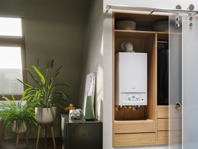 Die Gas-Brennwerttherme WLC und WLS, platzsparend in der Dachgeschosswohnung untergebracht auf rotem Hintergrund. Links davon ein helles, modern eingerichtetes Zimmer mit großem Tisch und grünen Stühlen.