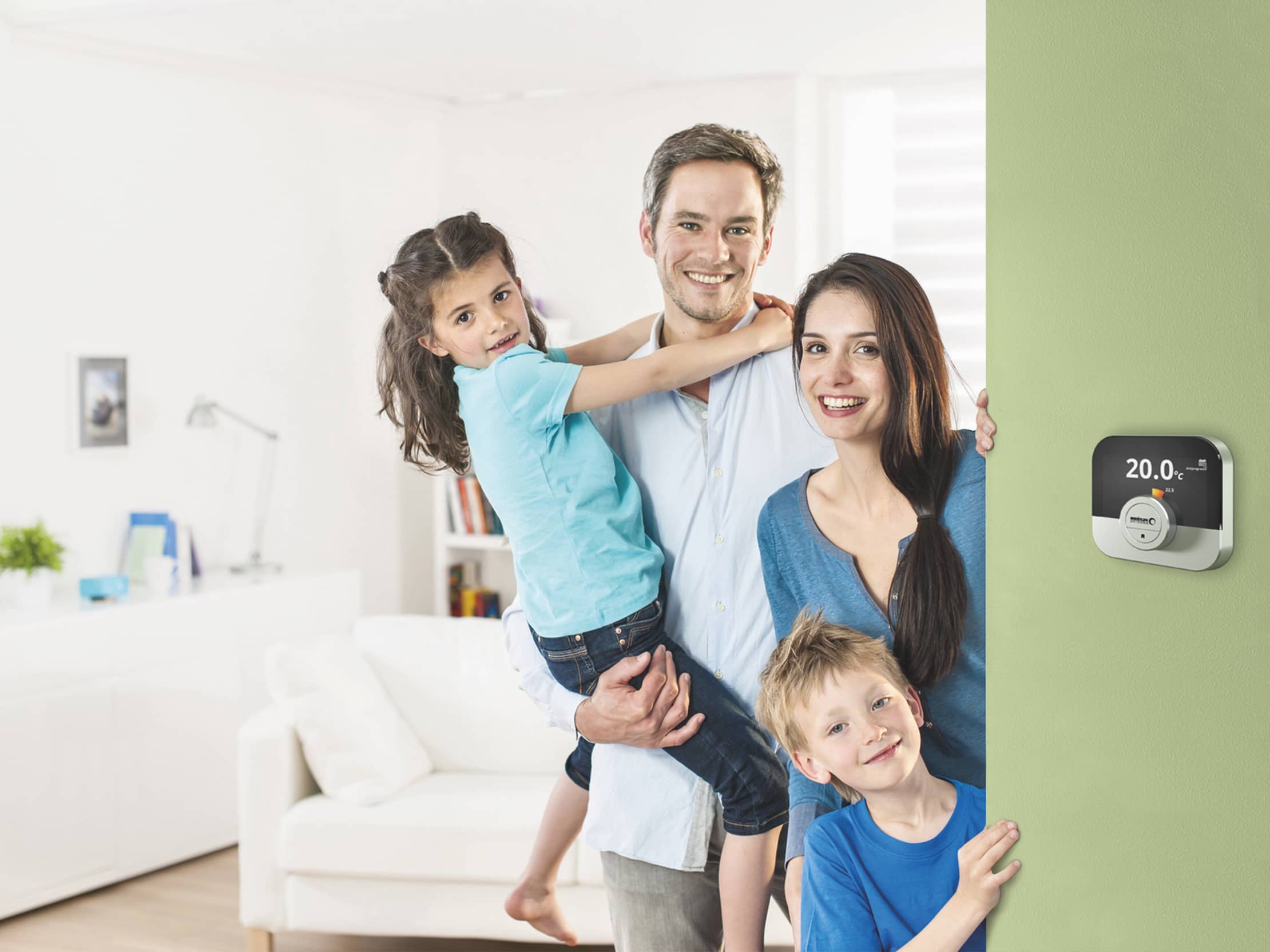Die Regelung IWR IDA an einer hellgrünen Wand, links davon steht eine junge Familie vor einem Wohnzimmer.