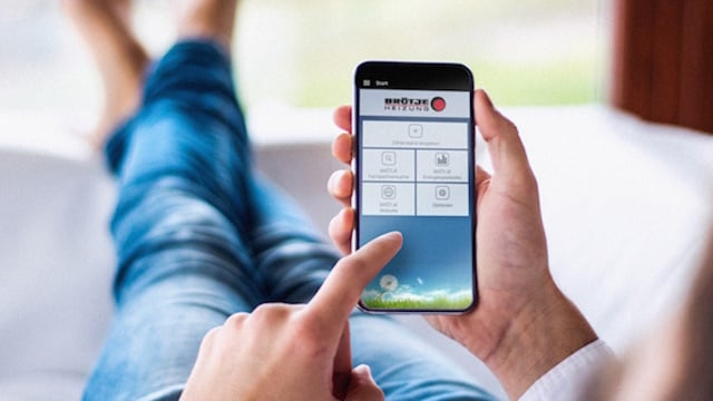 Mann liegt auf der Couch und nutzt auf seinem Smartphone die Apps von BRÖTJE