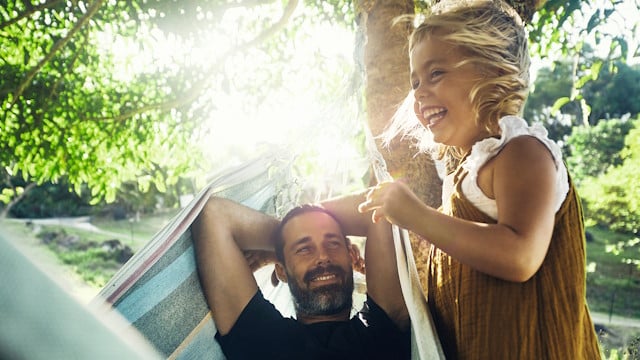 Vater und Tochter sprechen in der Natur darüber, wie sich Energie sparen lässt