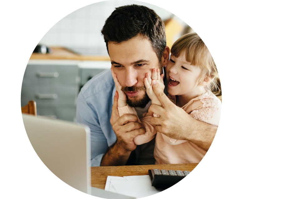 Vater und Tochter sitzen vor einem aufgeklappten Laptop und freuen sich über die Förderung rund um Ihre Heizungsanlage