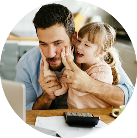 Vater und Tochter sitzen vor einem aufgeklappten Laptop und freuen sich über die Förderung rund um Ihre Heizungsanlage
