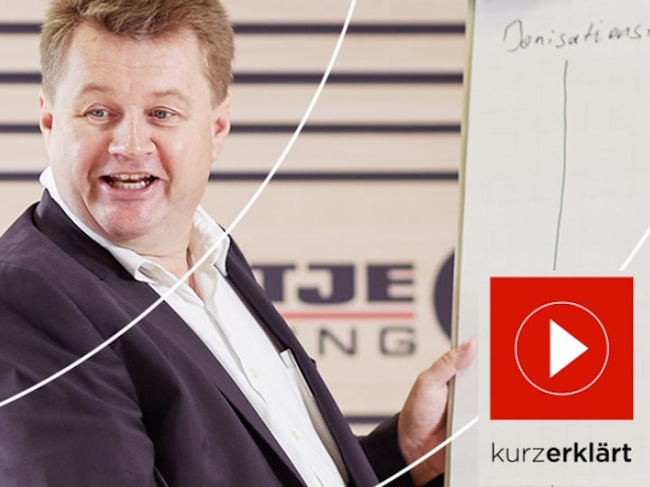 BRÖTJE Mitarbeiter erklärt etwas. unten rechts ist das Logo von "kurzerklärt" zu sehen
