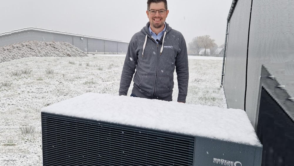 Produktmarketing-Manager Alexander Henne von BRÖTJE vor der Luft-Wasser-Wärmepumpe BLW Mono.1 bei winterlichen Temperaturen