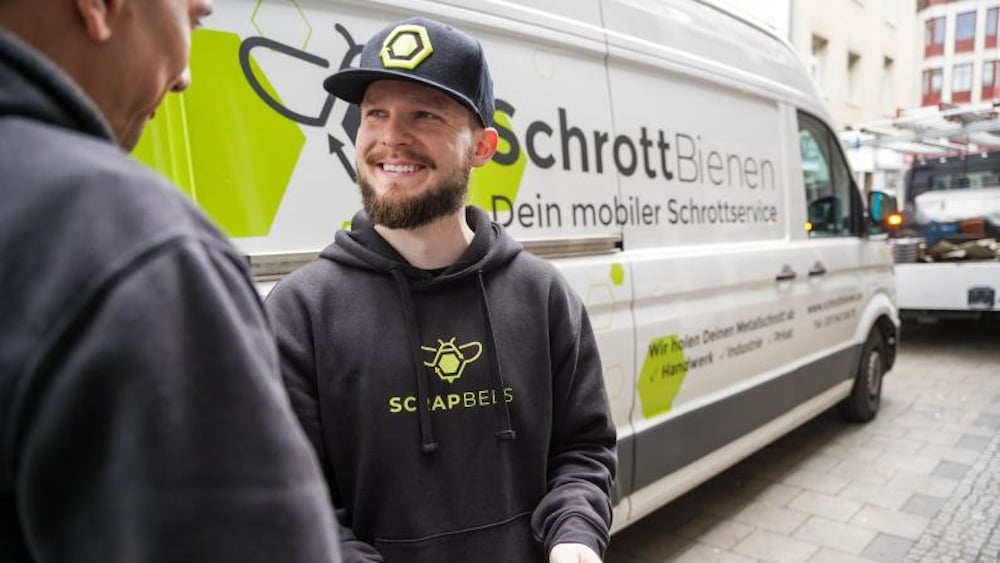 Zwei Männer unterhalten sich vor einem Transporter der Schrottbienen.