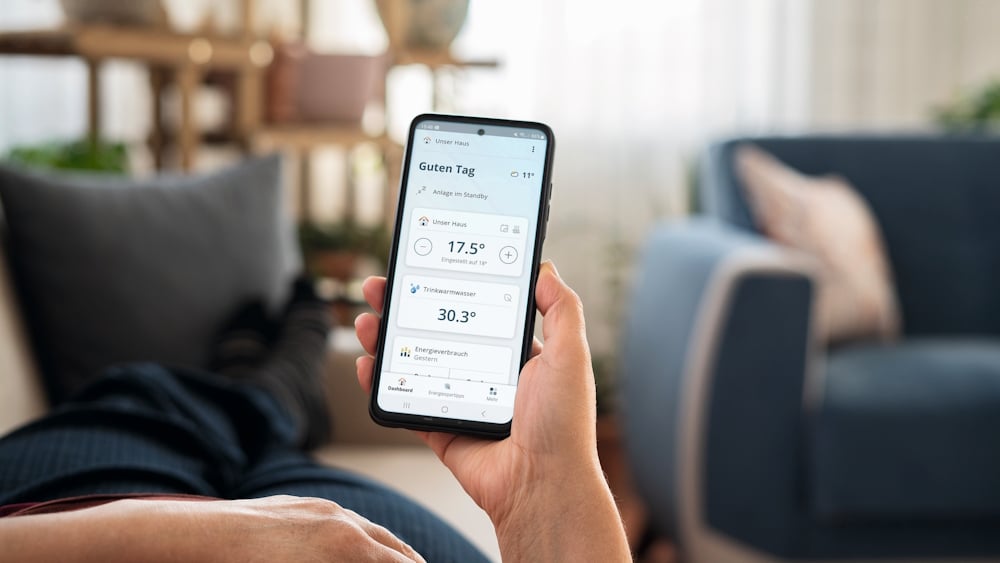 Ein Mann nutzt auf seinem Smartphone die Home Komfort App von BRÖTJE