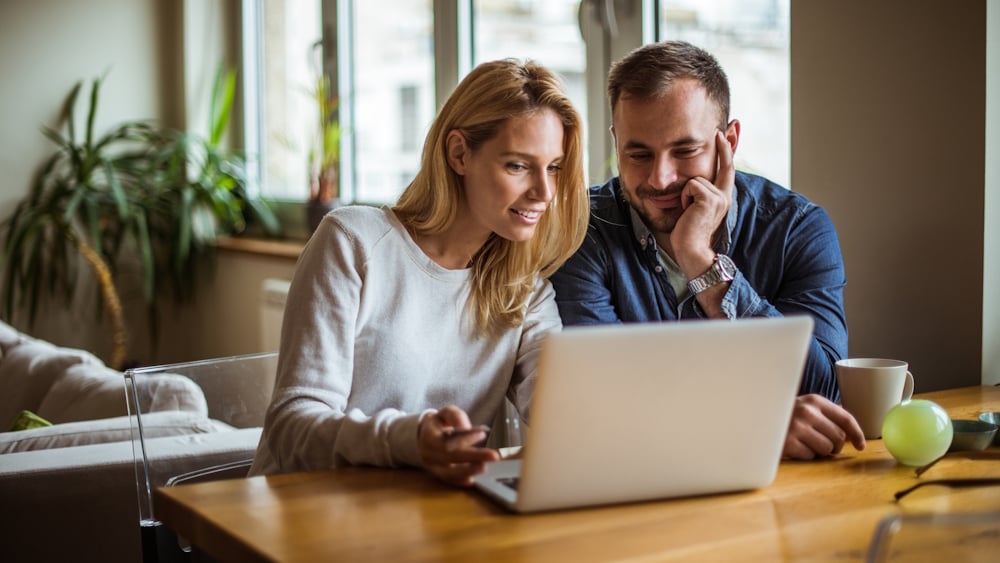 Ein Mann und eine Frau informieren sich beim Blick in den Laptop über die Heizungsförderung