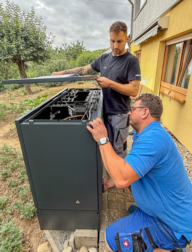 Handwerker installieren Luft-Wasser-Wärmepumpe 