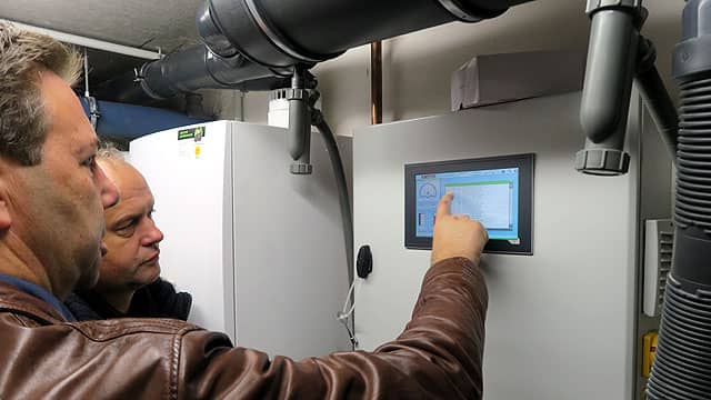 Remeha Referenz - Techniker erläutert Display an Heizungsanlage im MFH in Hamburg