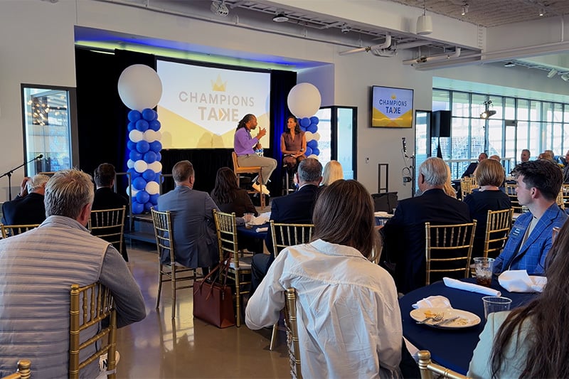 Champions Take: Larry Fitzgerald - Larry Fitzgerald and Lea Olsen sitting on stage talking to an audience 