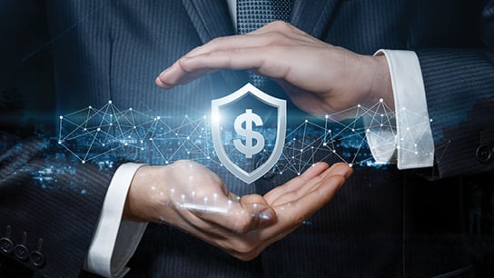 Businessman confidently holds a shield emblazoned with a dollar sign, symbolizing financial protection and security.