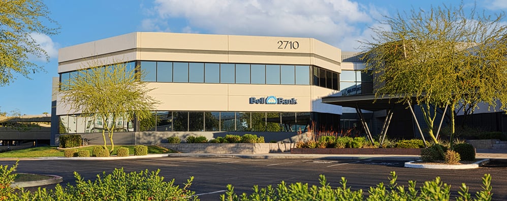 Exterior of Bell Bank Phoenix-Biltmore building with lush-green trees and plants surrounding.