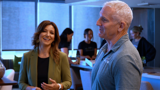 Bell Bank, In Business Together: Vet Tix insights article, candid shot Reina and Steven in office setting with workers in the background