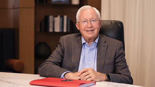 Bell Bank Chairman, Richard Solberg smiling while sitting at office desk