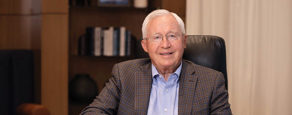 Bell Bank Chairman, Richard Solberg smiling while sitting at office desk
