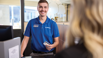 Photo of teller holding a debit card