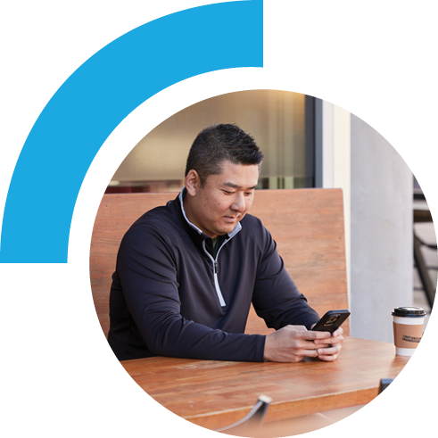 Man sitting in a cafe using a phone.