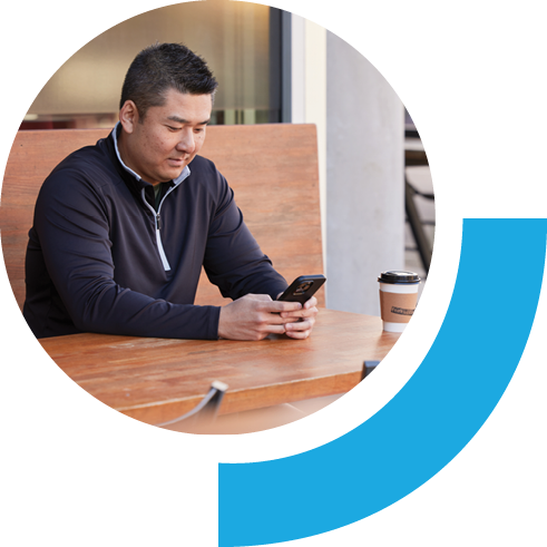 Man sitting in a cafe using a phone.
