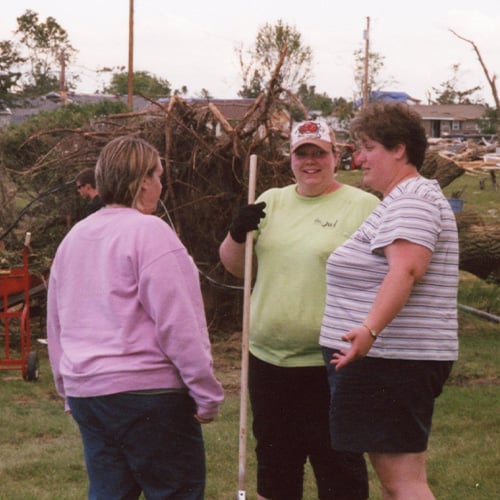 Pay It Forward Story - Bell employees helping to clean up after a storm. Fallen trees can be seen in the background.