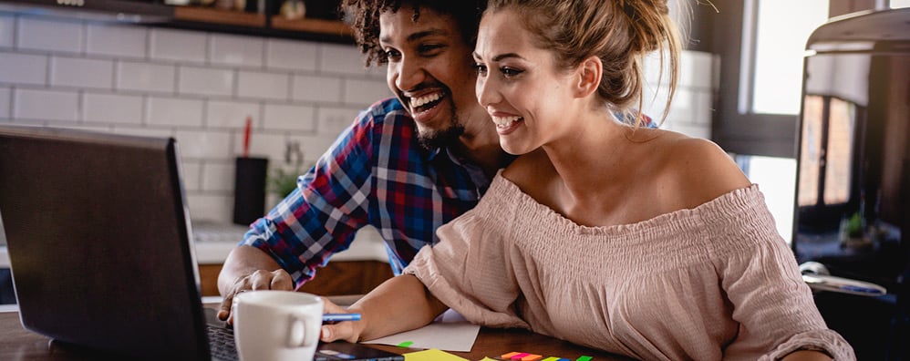 Couple looking at a laptop together in their home