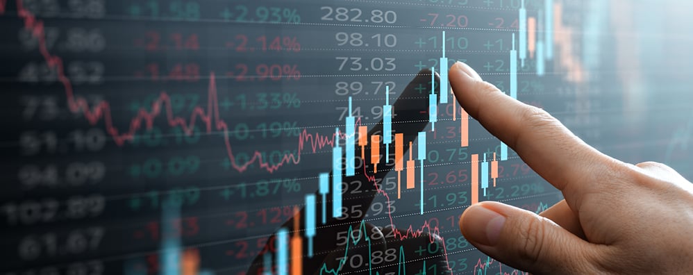 Finger pointing to a screen with stocks data