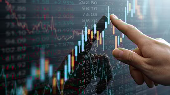 Finger pointing to a screen with stocks data