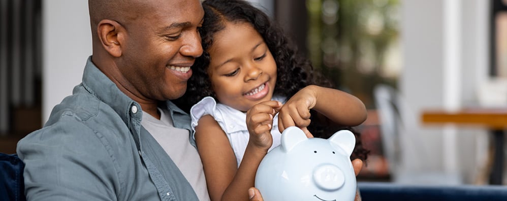 Father and daughter with a piggy bank.