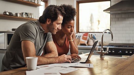 A couple on the kitchen island on their laptop