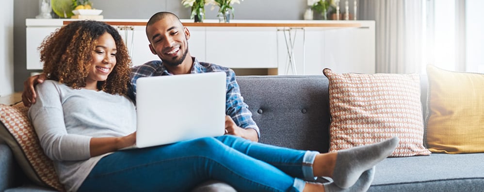 A couple on the couch on a laptop