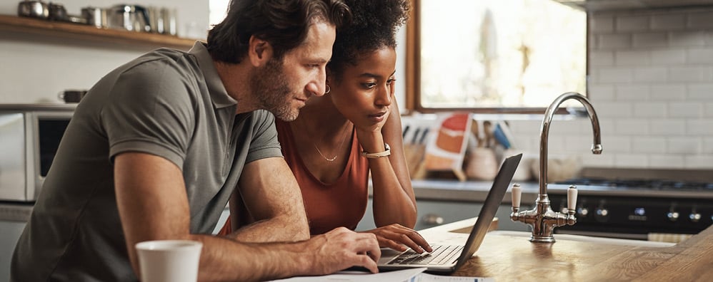 A couple on the kitchen island on their laptop