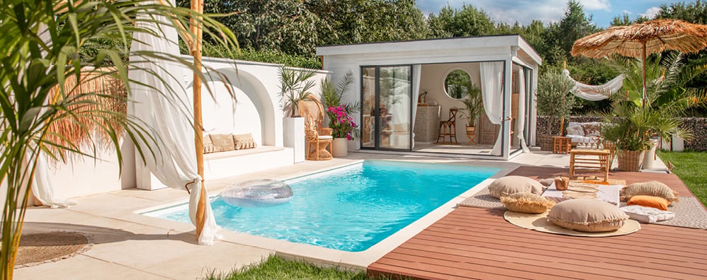 A backyard with a pool and pool house