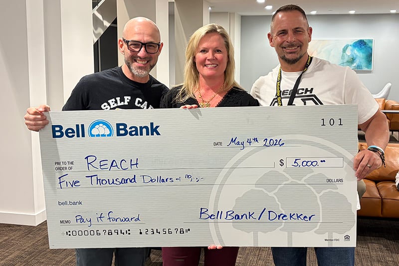 Three people holding a pay it forward check