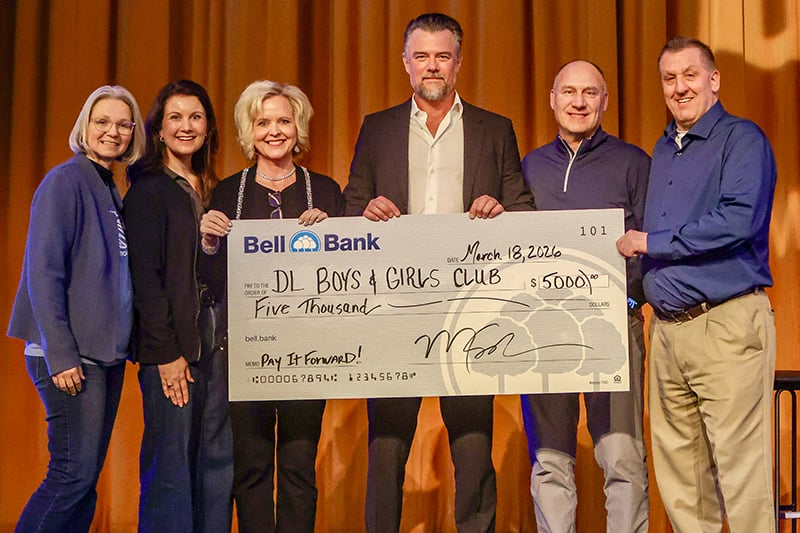 Six people holding a pay it forward check on stage