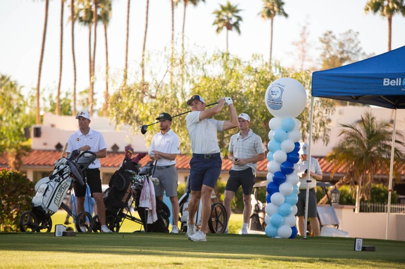 Pay It Forward Collegiate player swinging golf club while players watch