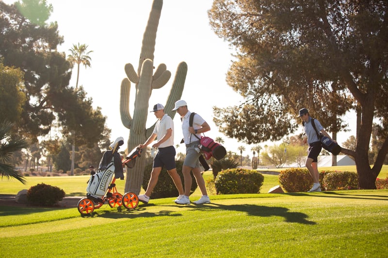 Pay It Forward Collegiate players walking on greens with cactus and trees