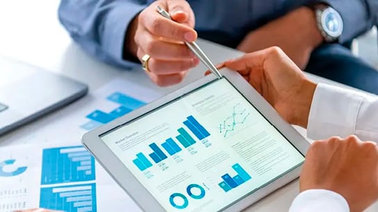 A tablet showing graphs with a hand pointing to it