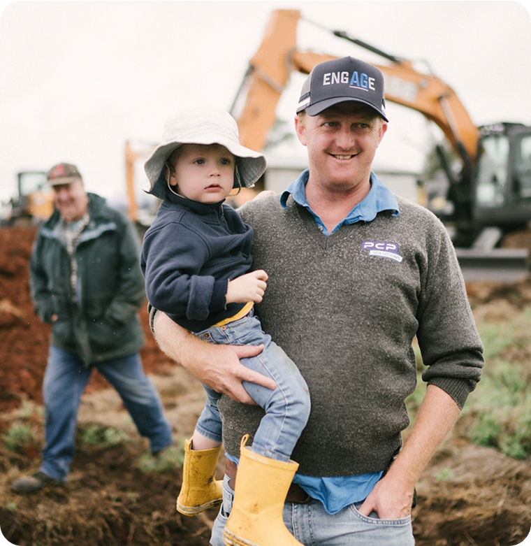 Team member from PCP Solutions smiling and as he holds his child 