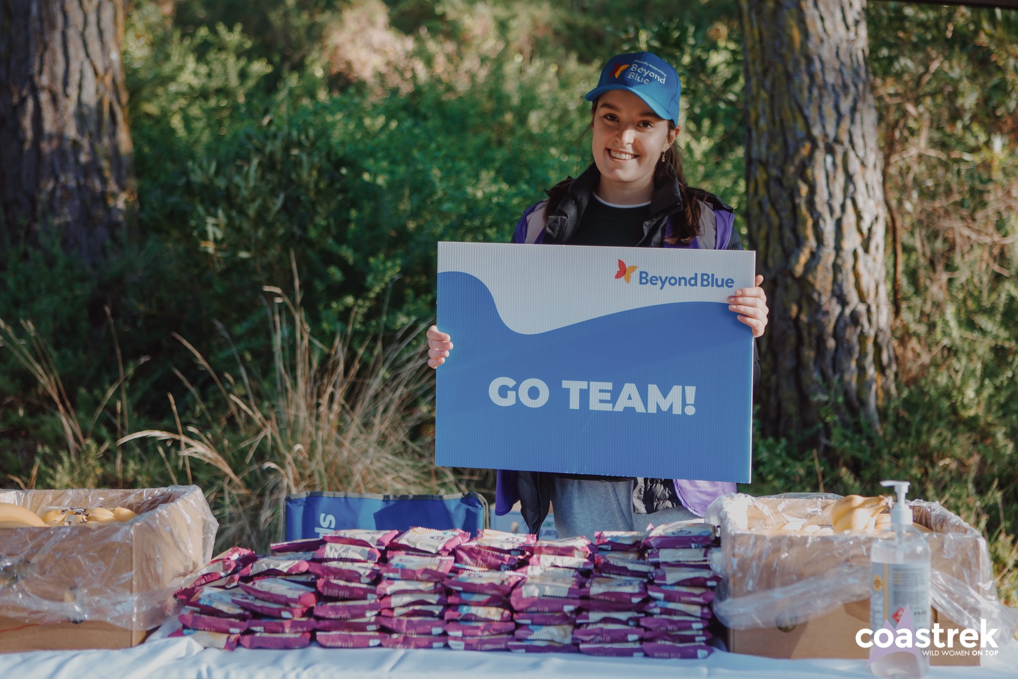Volunteer holds up sign that says Go Team